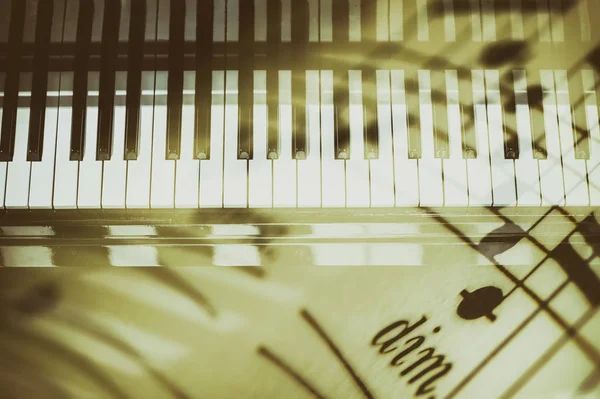 Πληκτρολόγιο πιάνου φόντο με επιλεκτική εστίαση. Διπλή έκθεση του πληκτρολογίου και μουσικές νότες — Φωτογραφία Αρχείου