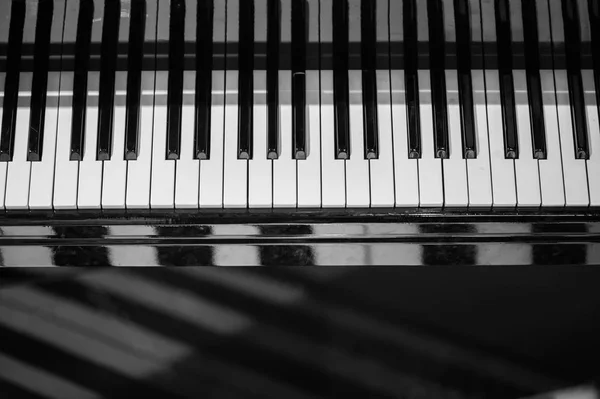 Fondo de teclado de piano con enfoque selectivo. Teclado desenfoque y notas musicales — Foto de Stock