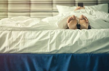 Kadın bacaklarını batımında battaniye altında. Görüntü'nün akıllı telefon olan dişi