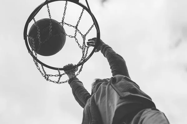 En liten pojke hoppar och gör mål spelar streetball, basket. Kastar en basket boll i ringen. Begreppet idrott — Stockfoto