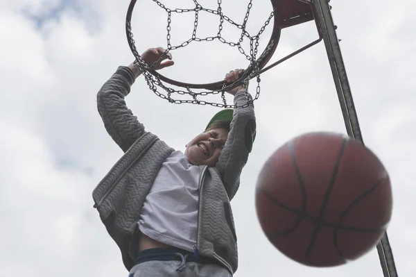 A little boy jumping and making goal playing streetball, basketball. Throws a basketball ball in the ring. The concept of sport — Stock Photo, Image