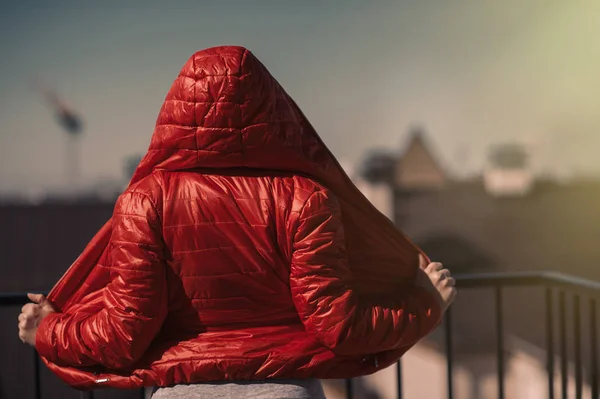 Schönes Mädchen in roter Jacke und Kopfhörer. ein Mädchen auf dem Balkon hört Musik und singt — Stockfoto