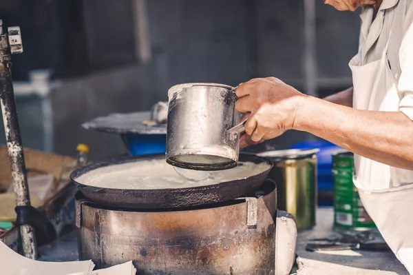 Bir adam içinde belgili tanımlık çarşı Çin mahallesini, Malezya bir pasta yemek pişiriyor. Sokak gıda.