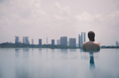 Güzel kız havuzu arka Malezya Putrajaya şehir üzerinde. Putrajaya gökdelenler