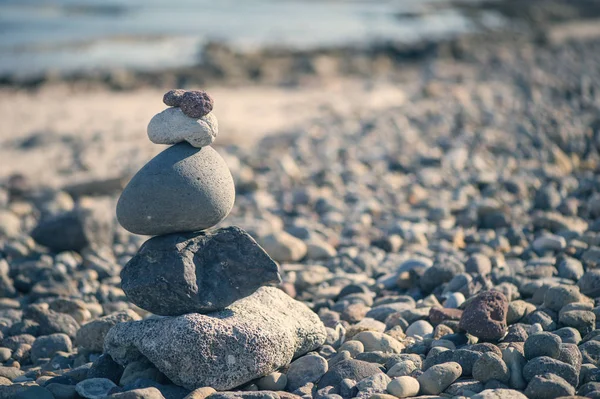 Piramis kövek a tengerparton a tenger ellen — Stock Fotó