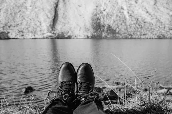 Pernas femininas em botas de caminhada pretas no fundo das montanhas de neve na Suíça. Neve nos sapatos femininos — Fotografia de Stock