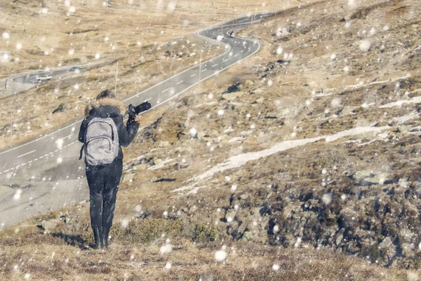 Fotograf kobieta z aparatu i plecak w zimowe kurtki z futerkiem na Śnieżce w Szwajcarii. Fluela przekazać w Szwajcarii w zimie. — Zdjęcie stockowe