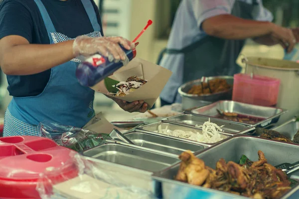 A woman selling a traditional local food Pecal on the the local market in Kuala lumpur. Local traditional street food  in Kuala lumpur, Malaysia