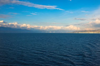 Yunanistan 'ın İyon Denizi' nde gün batımında Rion-Antirion köprüsü ve Patra limanındaki feribot gemisinden görüntü 
