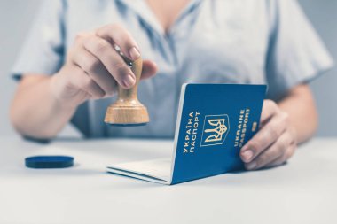 Havaalanında göçmenlik ve pasaport kontrolü. Kadın sınır kontrol memuru Ukrayna pasaportuna pul yapıştırıyor. Kavram