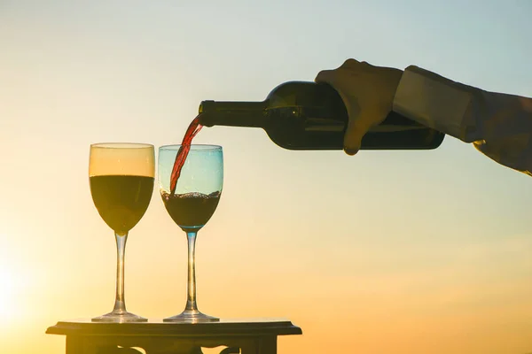 Mão Feminina Com Garrafa Derrama Vinho Tinto Copos Fundo Pôr — Fotografia de Stock