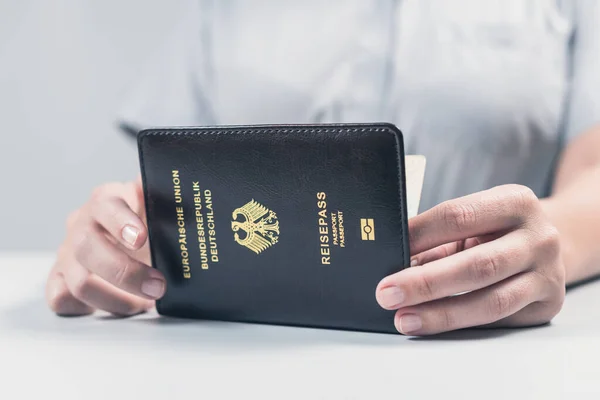 Immigration and passport control at the airport. woman border control officer with Deutsch passport of German citizen. Concept