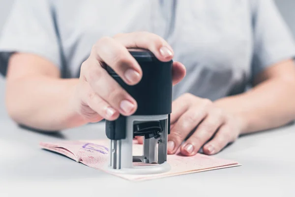 Immigration and passport control at the airport. woman border control officer puts a stamp in the passport. Concept