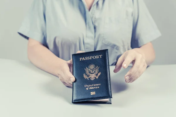 Immigration and passport control at the airport. woman border control officer with US passport of american citizen. Concept