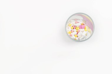 Renkli ilaçlarla, haplarla, vitaminlerle ya da takviyelerle dolu bir bardak. Bağımlılık tedavisi kavramı