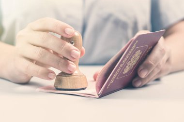 Havaalanında göçmenlik ve pasaport kontrolü. Kadın sınır kontrol memuru pasaportuna mühür basıyor. Kavram