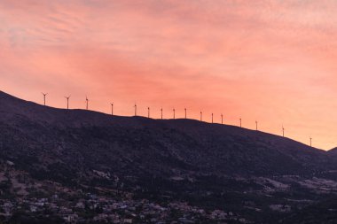 Yunanistan 'ın Kefalonia adasındaki dağdaki yel değirmenlerinin gün batımı manzarası.