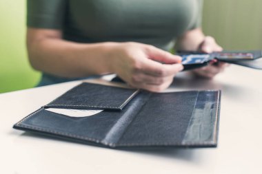 Kafe masasında elinde dosya ve fatura olan kadın eli resmi var. Restoran ziyaretçisi kredi kartıyla ödemeye hazır.