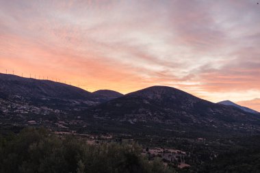 Yunanistan 'ın Kefalonia adasındaki dağdaki yel değirmenlerinin gün batımı manzarası.