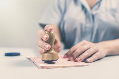 Havaalanında göçmenlik ve pasaport kontrolü. Kadın sınır kontrol memuru pasaportuna mühür basıyor. Kavram