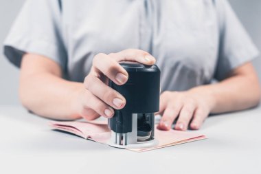Havaalanında göçmenlik ve pasaport kontrolü. Kadın sınır kontrol memuru pasaportuna mühür basıyor. Kavram