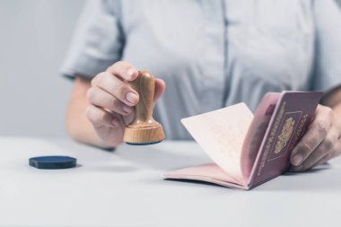 Havaalanında göçmenlik ve pasaport kontrolü. Kadın sınır kontrol memuru pasaportuna mühür basıyor. Kavram