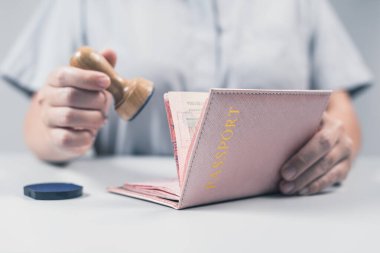 Havaalanında göçmenlik ve pasaport kontrolü. Kadın sınır kontrol memuru pasaportuna mühür basıyor. Kavram