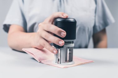 Havaalanında göçmenlik ve pasaport kontrolü. Kadın sınır kontrol memuru pasaportuna mühür basıyor. Kavram