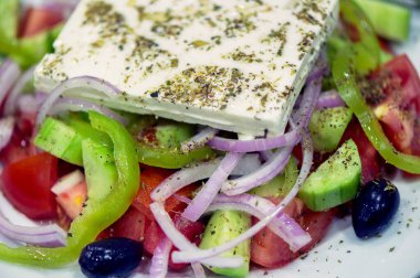 Domatesler, salatalıklar, kırmızı biber, zeytinli soğan, kekik ve peynirli klasik Yunan salatası..