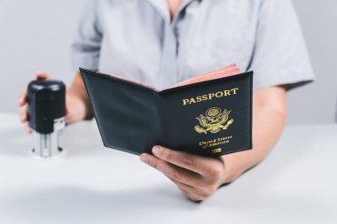 Havaalanında göçmenlik ve pasaport kontrolü. Kadın sınır kontrol memuru Amerikan vatandaşının pasaportuna mühür basıyor. Kavram