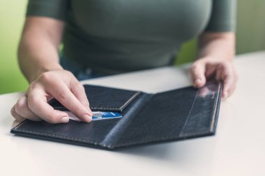 Kafe masasında elinde dosya ve fatura olan kadın eli resmi var. Restoran ziyaretçisi kredi kartıyla ödemeye hazır.