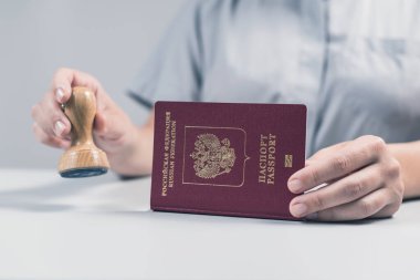 Havaalanında göçmenlik ve pasaport kontrolü. Kadın sınır kontrol memuru pasaportuna mühür basıyor. Kavram