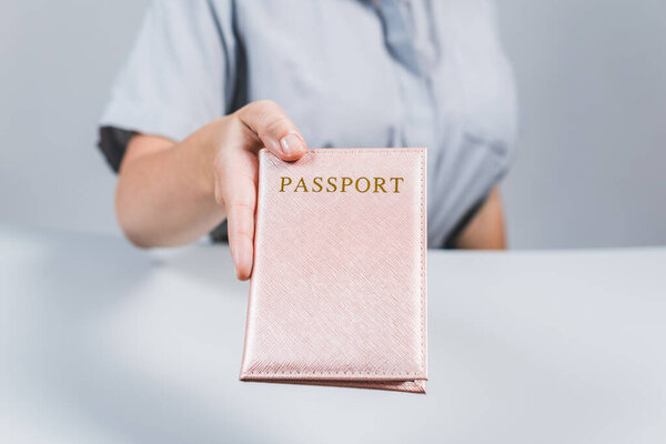 Иммиграционный и паспортный контроль в аэропорту. женщина-пограничник с паспортом в розовой обложке. Концепция
