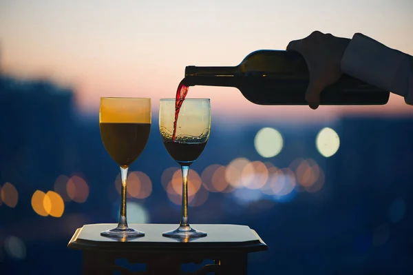 Kvinnlig Hand Med Flaska Häller Rött Vin Glas Suddig Natt — Stockfoto