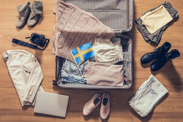 Ubrania Damskie Laptop Aparat Fotograficzny Flaga Szwecji Leżące Parkiecie Pobliżu — Zdjęcie stockowe