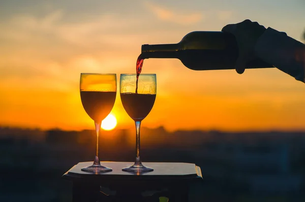 Eine Weibliche Hand Mit Flasche Gießt Rotwein Gläser Vor Sonnenuntergang — Stockfoto