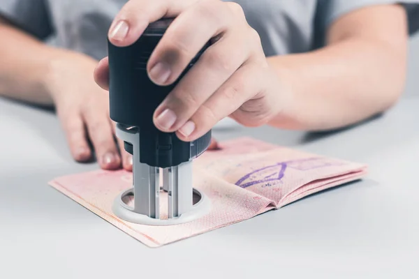 Immigration and passport control at the airport. woman border control officer puts a stamp in the passport. Concept