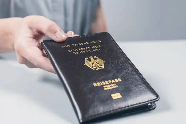 Immigration and passport control at the airport. woman border control officer with Deutsch passport of German citizen. Concept