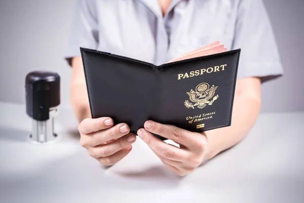 Immigration and passport control at the airport. woman border control officer puts a stamp in the US passport of american citizen. Concept