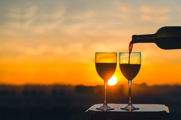 Eine Weibliche Hand Mit Flasche Gießt Rotwein Gläser Vor Sonnenuntergang — Stockfoto