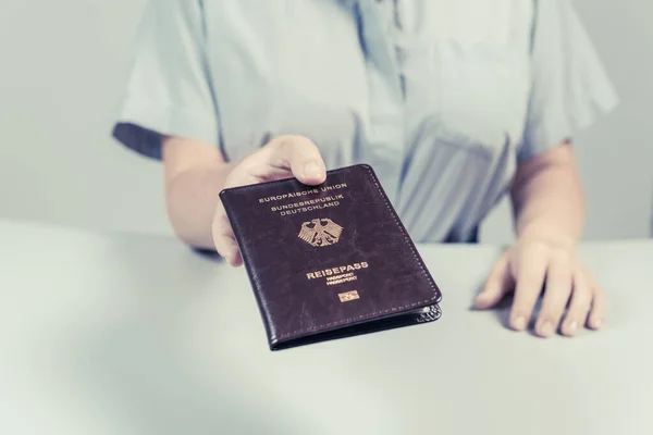 Immigration and passport control at the airport. woman border control officer with Deutsch passport of German citizen. Concept