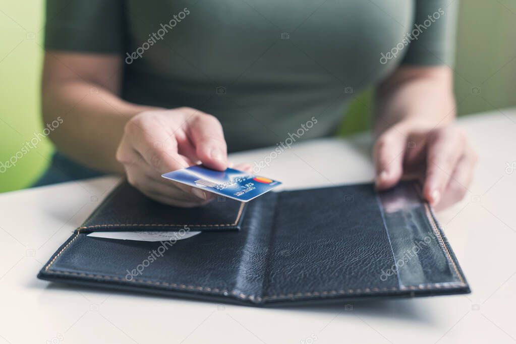 Cropped image of  woman hands with folder and bill on the table of cafe. visitor of restaurant ready to pay by credit card