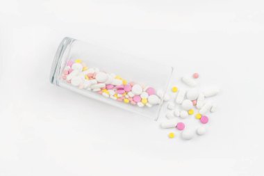 Renkli ilaçlarla, haplarla, vitaminlerle ya da takviyelerle dolu bir bardak. Bağımlılık tedavisi kavramı