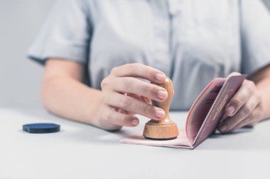 Havaalanında göçmenlik ve pasaport kontrolü. Kadın sınır kontrol memuru pasaportuna mühür basıyor. Kavram