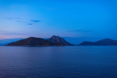 Günbatımında feribottan Yunan adası Atokos manzarası. İyon Denizi 'ndeki Yunan adaları