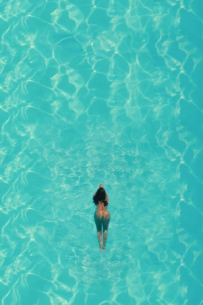 蓝水游泳池里裸体女子的空中俯瞰 — 图库照片