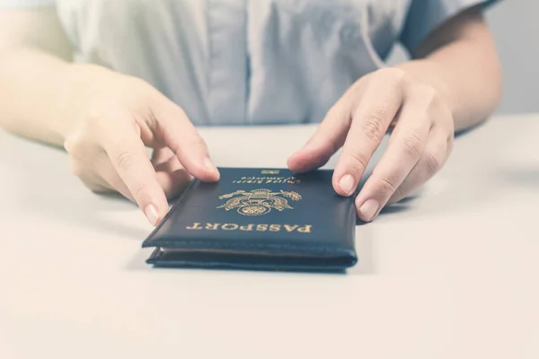 Immigration and passport control at the airport. woman border control officer with US passport of american citizen. Concept