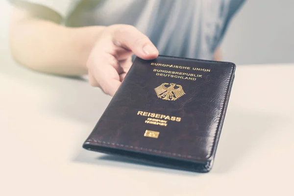 Immigration and passport control at the airport. woman border control officer with Deutsch passport of German citizen. Concept