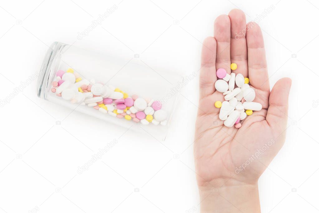 Female hand and glass full of colorful medicines,pills, Sleeping pills, sedative. The concept of addiction treatment
