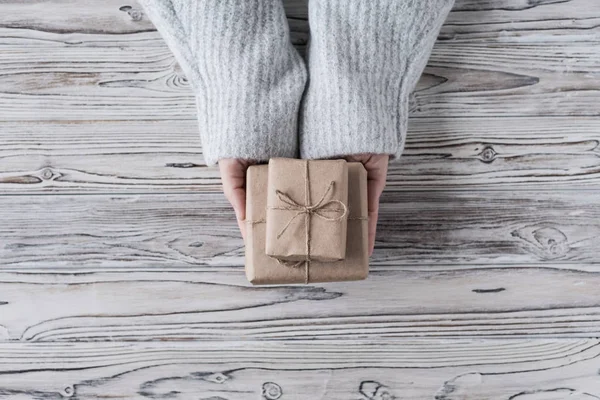 女性包装礼物 纸板箱在工艺纸 圣诞绳和树在乡村木板的背景 — 图库照片